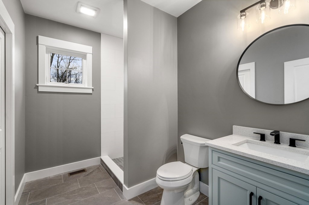 Custom bathroom vanity with oval mirror by Wingspan Properties